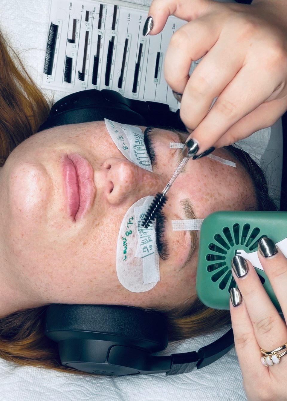 Ciera brushing through a client's lashes mid appointment