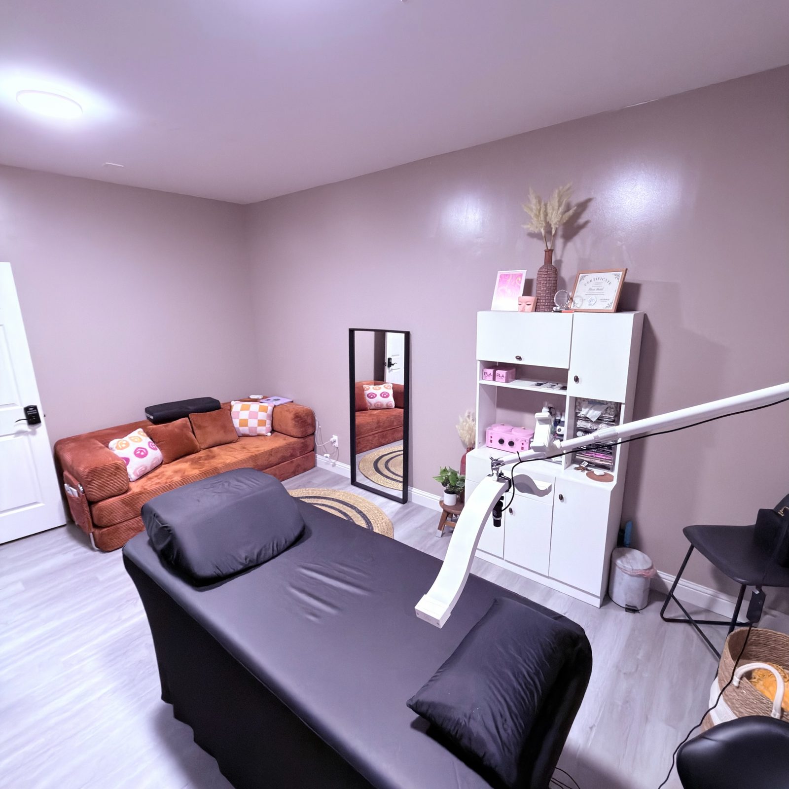 Inside the studio: treatment bed, couch and shelving at Suite 400